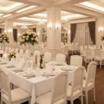 Elegancka sala weselna w Krakowie z białym wyposażeniem, oświetleniem i dekoracjami, przygotowana na wesele