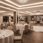 Elegancka sala weselna we Wrocławiu z oświetleniem, stołami przystrojonymi na wesele, widokiem na parkiet taneczny